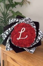 red inital bouquet with black & white dior wrapping